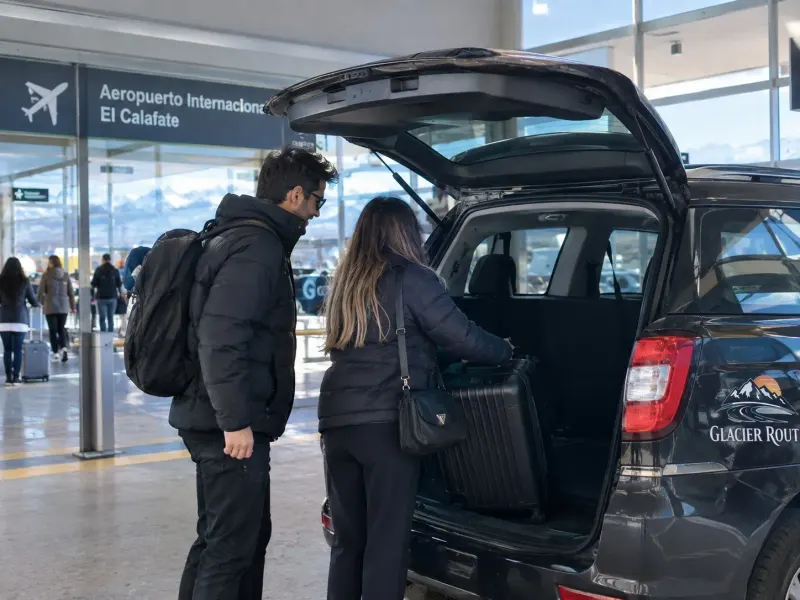 Pareja cargando una valija en la camioneta de Glacier Route para volver al aeropuerto
